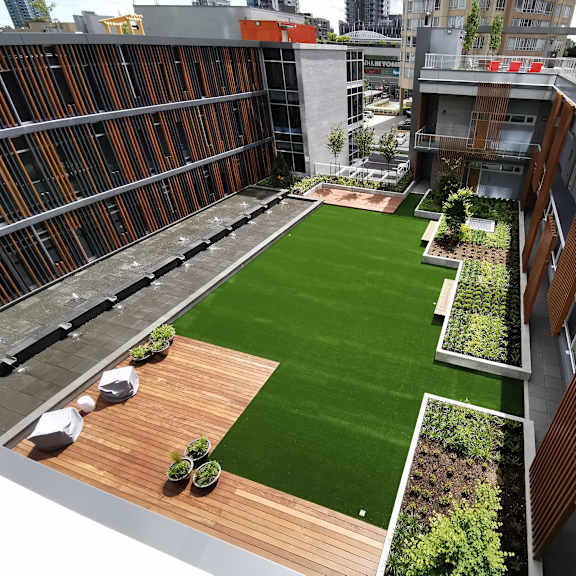 a rooftop garden with green grass and wooden planters.