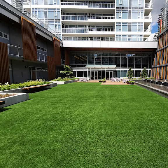 a large grassy area in front of a modern building.