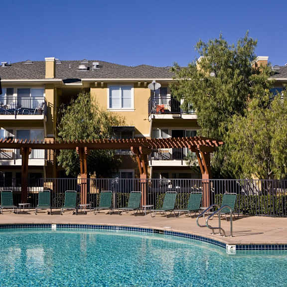 a large swimming pool in front of a large house