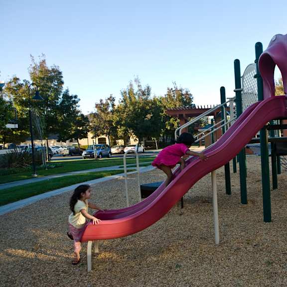 a girl playing on a slide on a playground