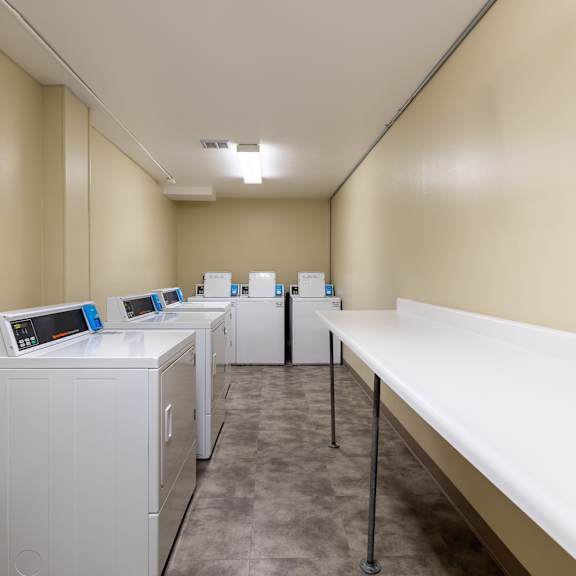 a row of washing machines are lined up in a laundry room.
