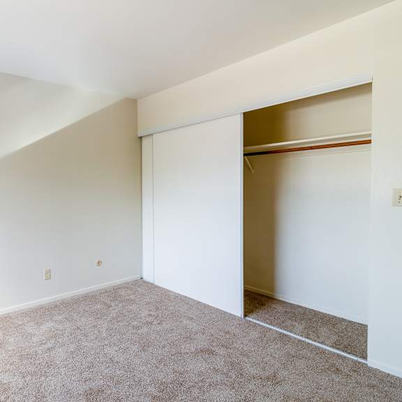 a room with a carpeted floor and a window on the left side.
