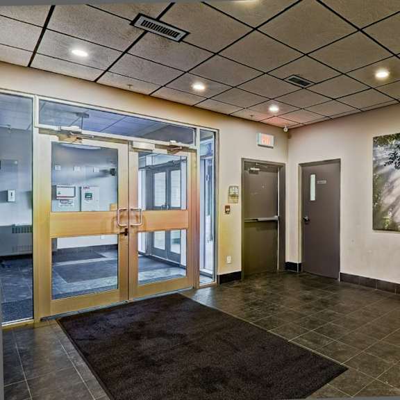 a hallway with a rug on the floor and a painting on the wall.