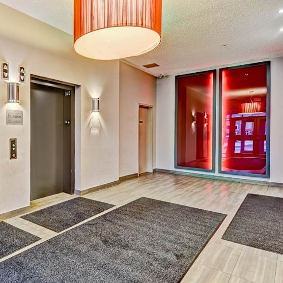 a hallway with a red light and a black door.