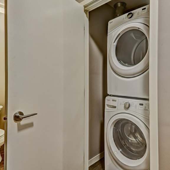 a white door opens to a small laundry room with a washer and dryer.