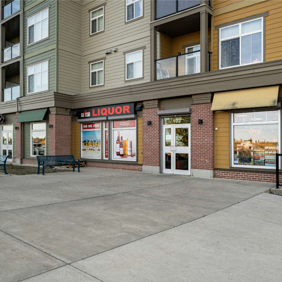 an empty sidewalk in front of a large apartment building
