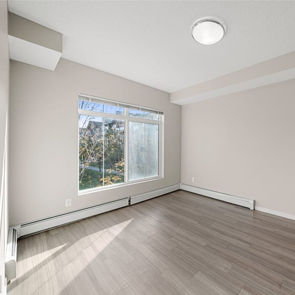an empty room with wood floors and a window