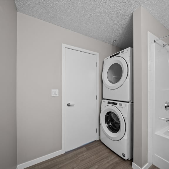 the living room has a washer and dryer and a door to the bathroom