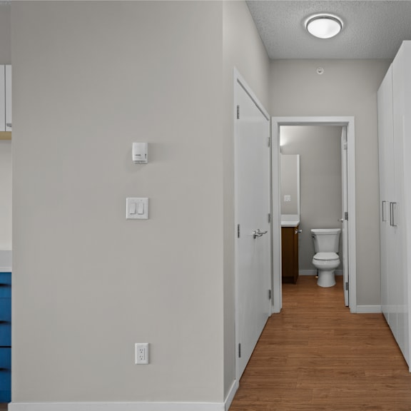 a corridor with white walls and a toilet in a bathroom
