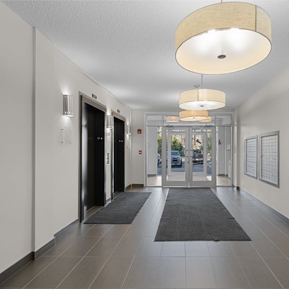 a hallway with doors and rugs in a building with white walls