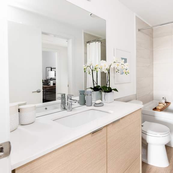 a white bathroom with a toilet, sink, and bathtub.