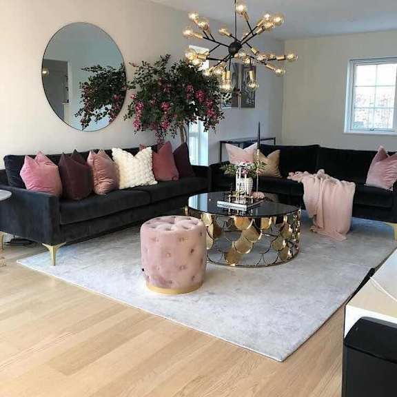 Thumbnail 2 of 4 a living room with black furniture and pink pillows