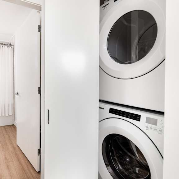 a white washing machine in a laundry room.