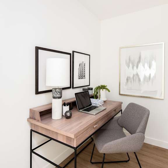 a desk with a laptop and a plant on it.