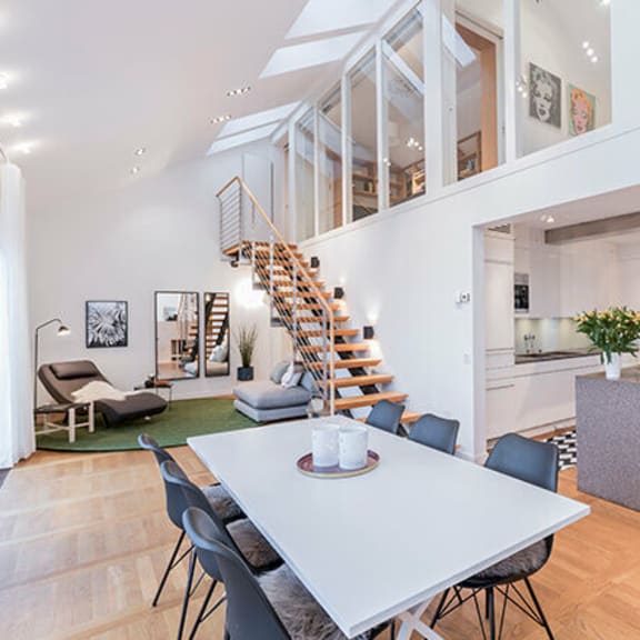 a living room and dining room with a staircase in a house
