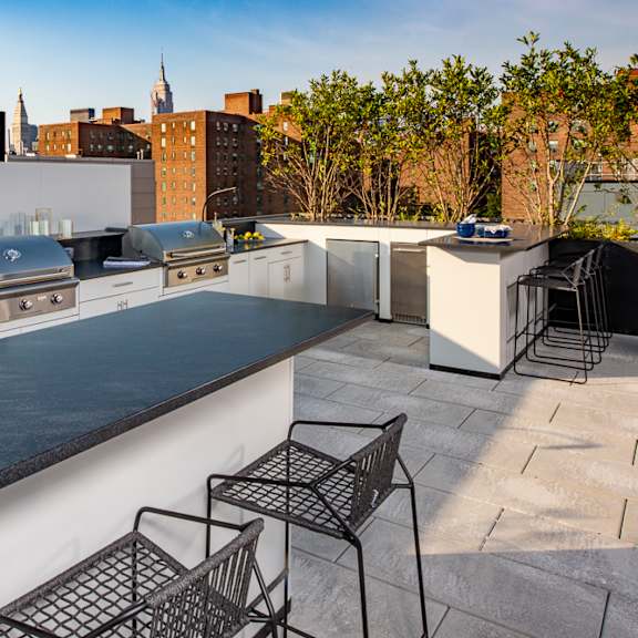 a kitchen and dining area on a roof with a city skyline in the background