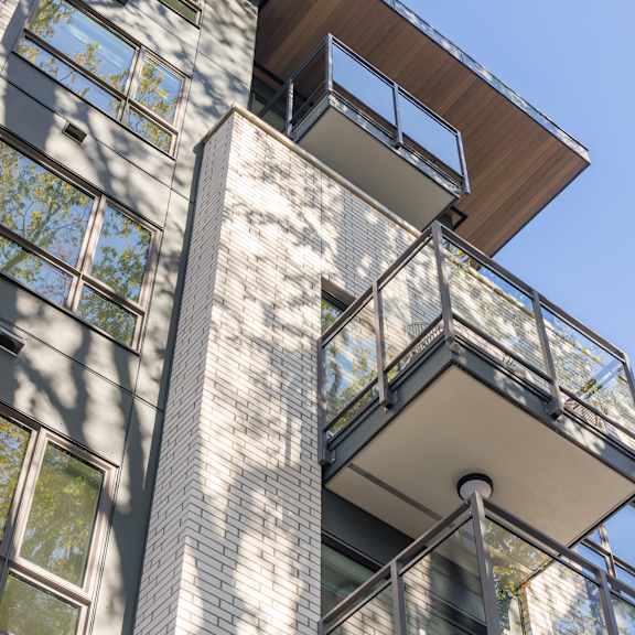 a tall building with a balcony and a lot of windows.