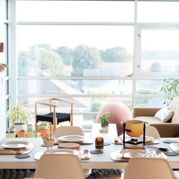 a dining room with a table and chairs in front of a window