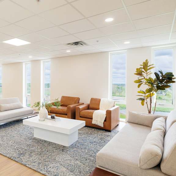 a spacious living room with a variety of seating options and a large window.