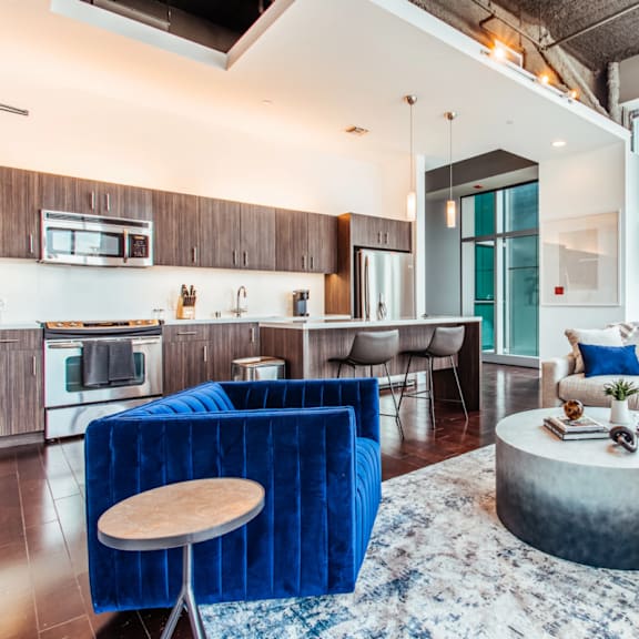 a living room with a couch coffee table and a kitchen with a breakfast bar