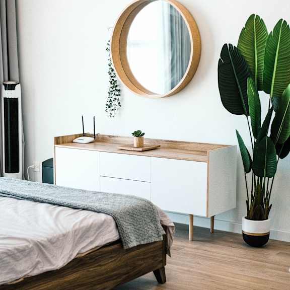 a bedroom with a mirror and a bed and a plant