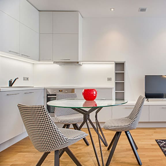 a modern kitchen with a glass table and chairs.