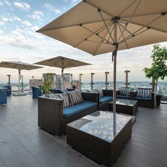 a patio with a table and chairs under a large umbrella.