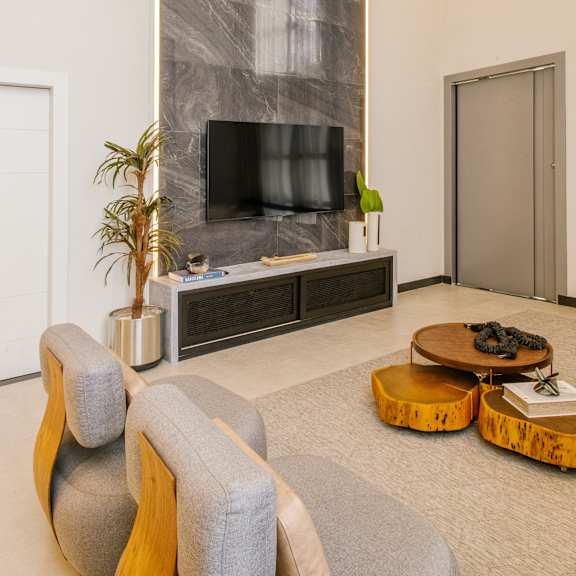 a living room with a tv on the wall and a coffee table in front of it