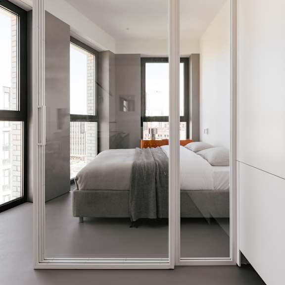 a bedroom with a bed and a large mirror on the wall.