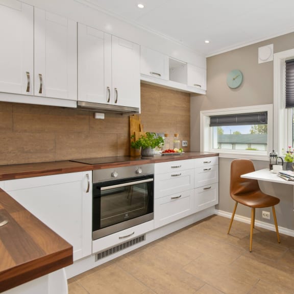 a kitchen with white cabinets and a table and chairs