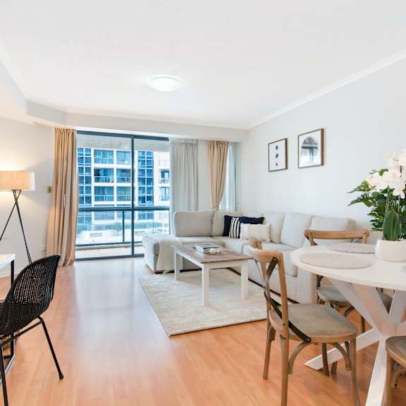 a living room and dining room with a table and chairs
