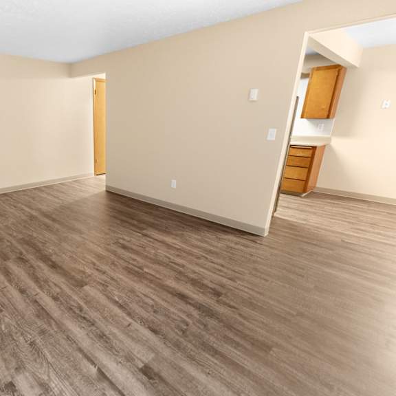 a room with wooden flooring and a door on the left.