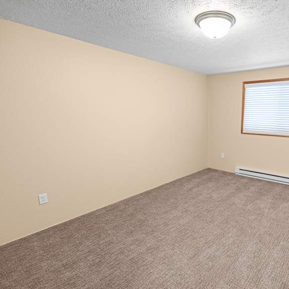 a room with a window and a carpeted floor.