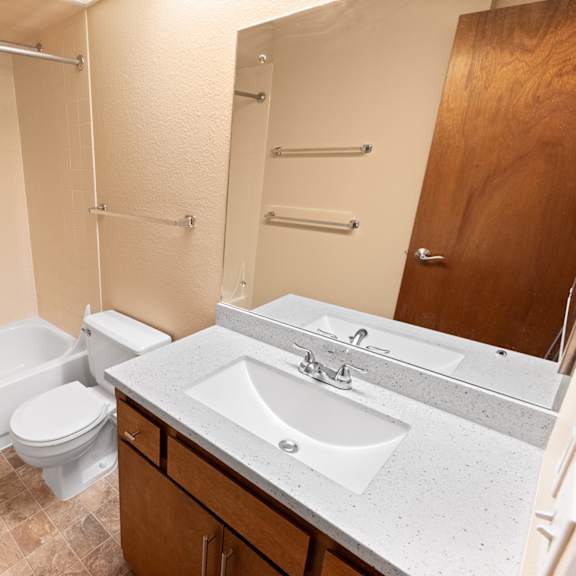 a bathroom with a white tub, toilet, and sink.