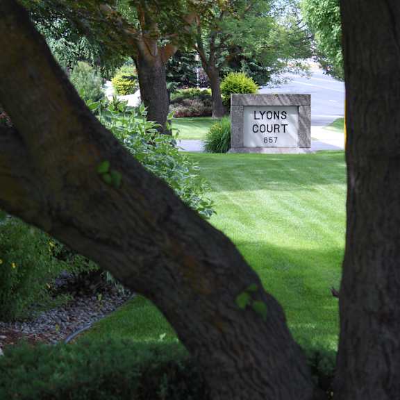 a sign that says lyons court stands in a green field.