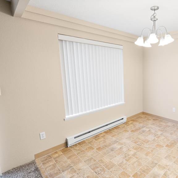 a room with a tiled floor and a window with blinds.