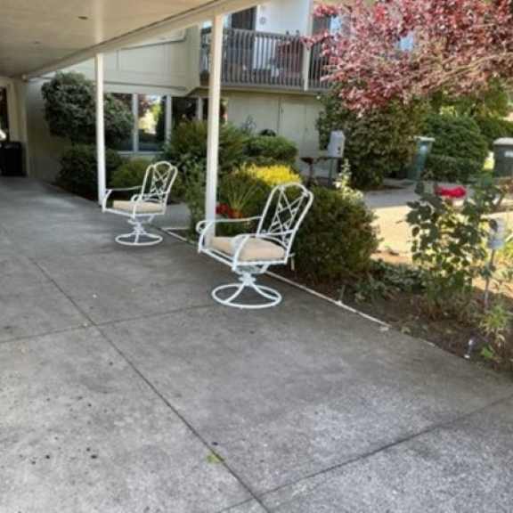 a couple of white chairs sitting in front of a building