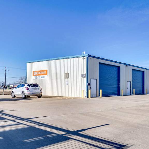 a large industrial building with a car parked in front of it.