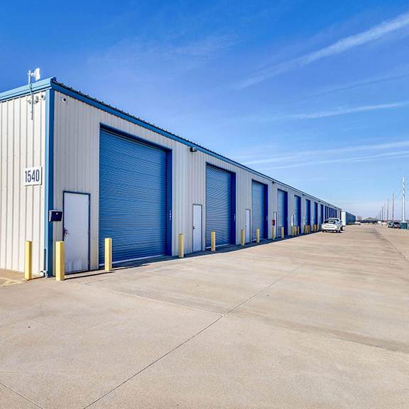 a large industrial building with a blue and white exterior and a sign that reads "entrance".