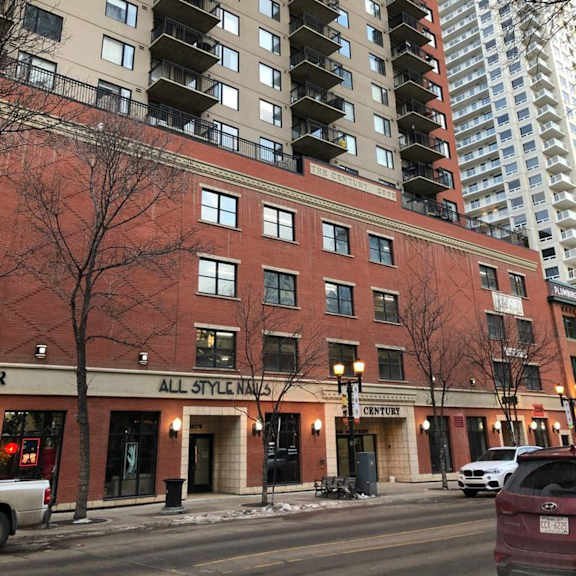 a red brick building with a sign that says "all style nails" and "century".