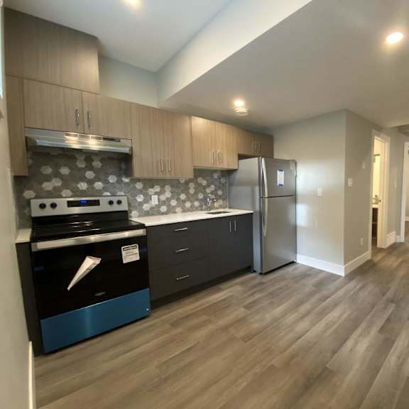 a kitchen with a stove top oven and a refrigerator.
