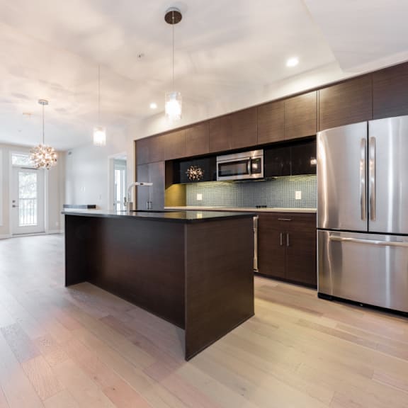 a modern kitchen with stainless steel appliances and wooden cabinets.