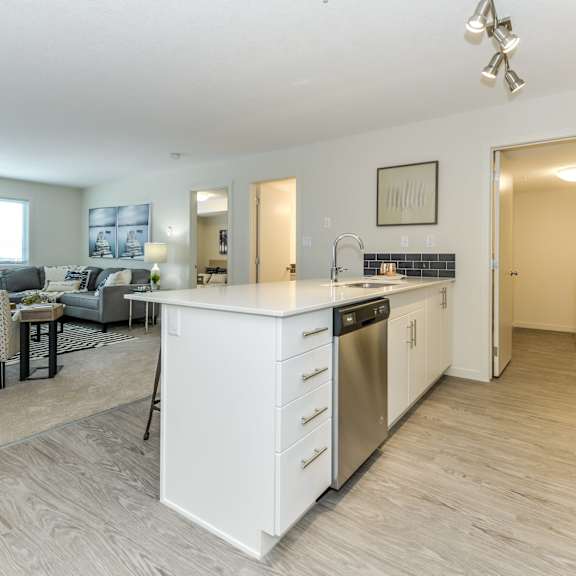 a modern kitchen with a dining area and a living room.