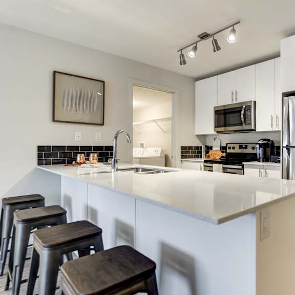 a kitchen with a white counter top and stainless steel appliances.