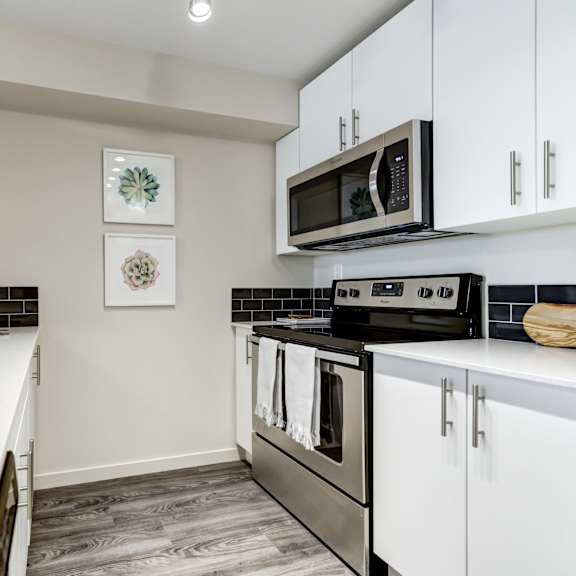 a kitchen with white cabinets and a black stove top oven.