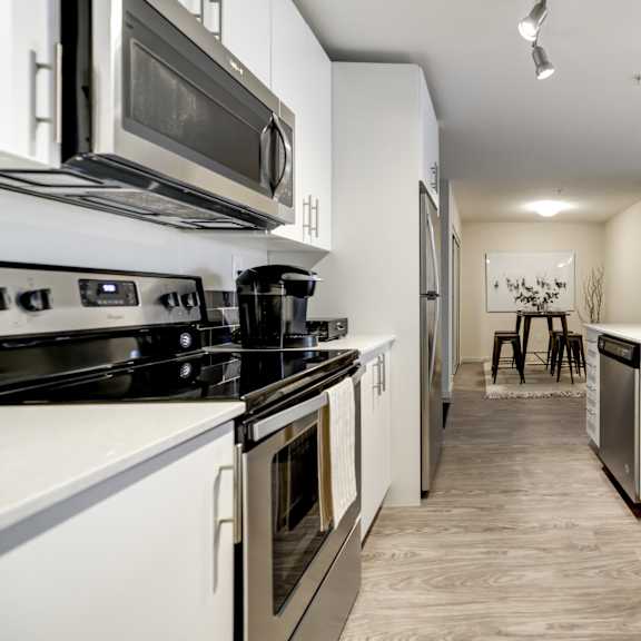 a modern kitchen with white appliances and cabinets.