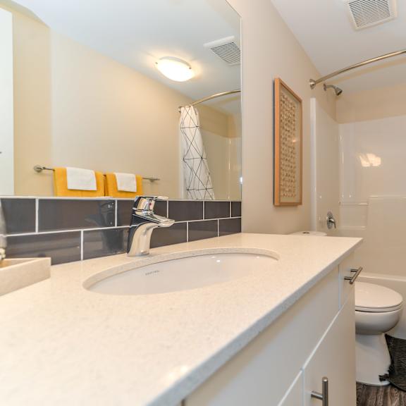 a bathroom with a white counter top and a white sink.