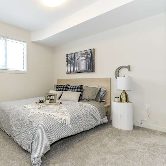 a bedroom with a bed, a lamp, and a deer head on the wall.