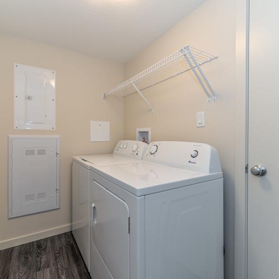 a small white washer and dryer in a laundry room.