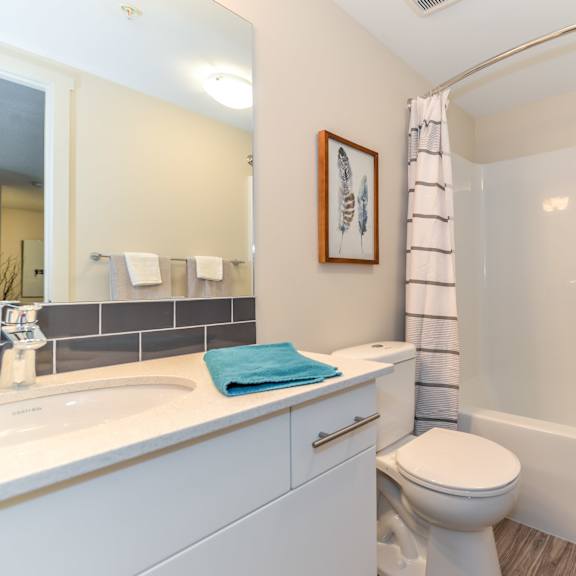 a white bathroom with a toilet, sink, and bathtub.